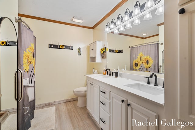 bathroom with ornamental molding, toilet, wood finished floors, double vanity, and baseboards
