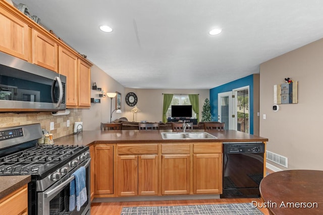 8485 E Center Park Dr SW Unit 18, Byron Center, MI 49315 - kitchen with appliances with stainless steel finishes, a sink, a peninsula, dark countertops, and tasteful backsplash