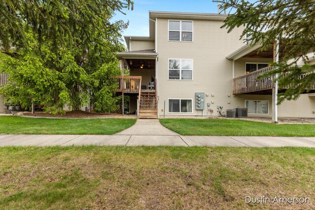 8485 E Center Park Dr SW Unit 18, Byron Center, MI 49315 - back of property featuring a yard, stairs, a wooden deck, and central AC