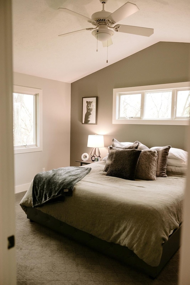 carpeted bedroom featuring lofted ceiling and a ceiling fan