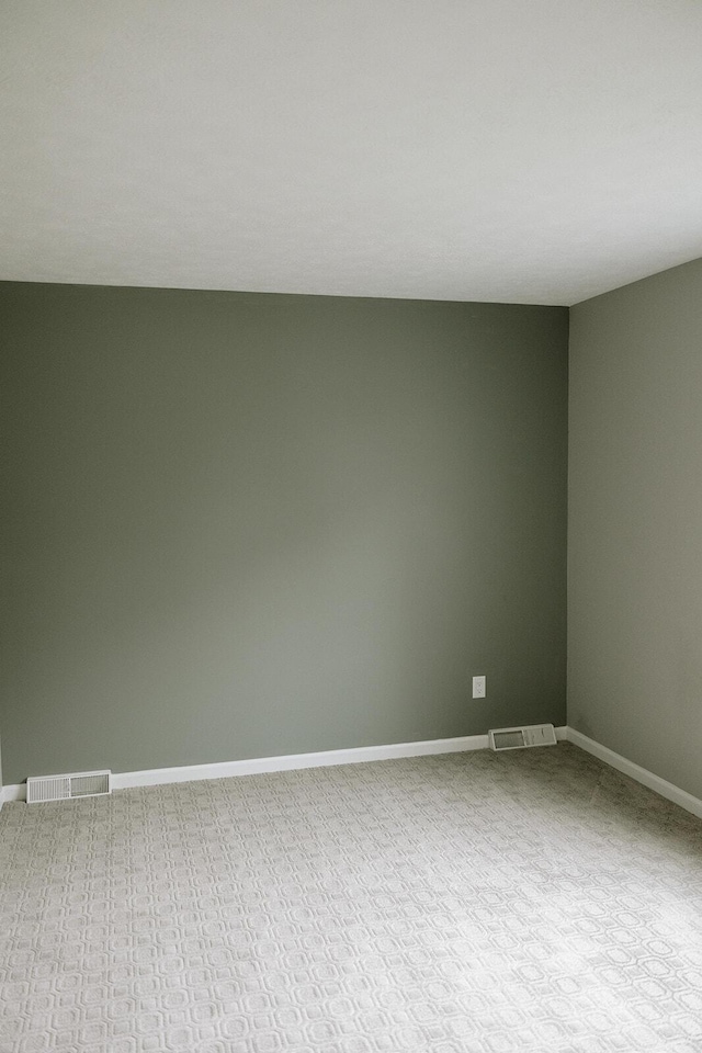 empty room featuring carpet floors and baseboards