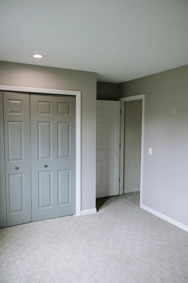 unfurnished bedroom with carpet, baseboards, a closet, and recessed lighting
