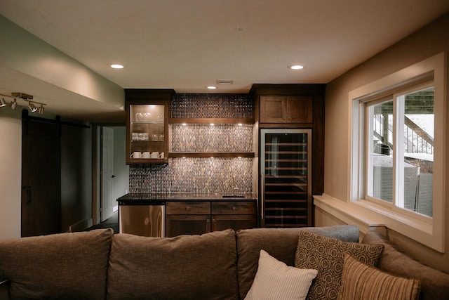 indoor dry bar with wine cooler, a barn door, decorative backsplash, fridge, and recessed lighting
