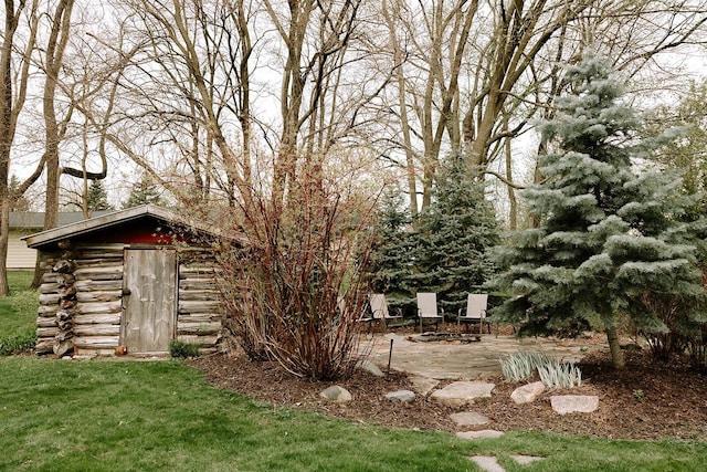 view of grassy yard with an outdoor structure, a patio area, and a storage unit
