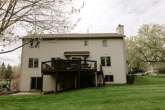 back of property featuring a wooden deck, a chimney, a lawn, and stairs