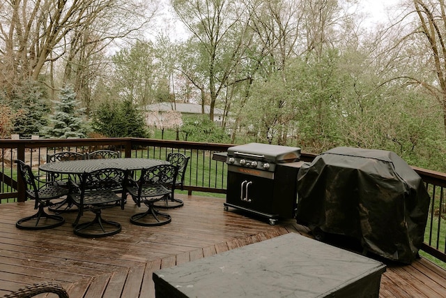 wooden deck with outdoor dining space and area for grilling