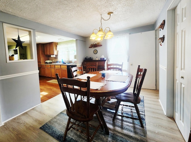 3034 Royalton Heights Rd, Saint Joseph, MI 49085 - dining area with light wood finished floors, a chandelier, healthy amount of natural light, a textured ceiling, and baseboards