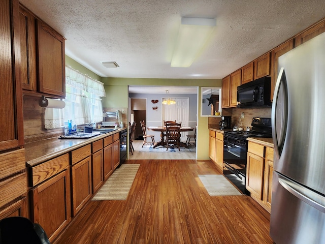 3034 Royalton Heights Rd, Saint Joseph, MI 49085 - kitchen featuring black appliances, dark wood-type flooring, brown cabinetry, a textured ceiling, and backsplash