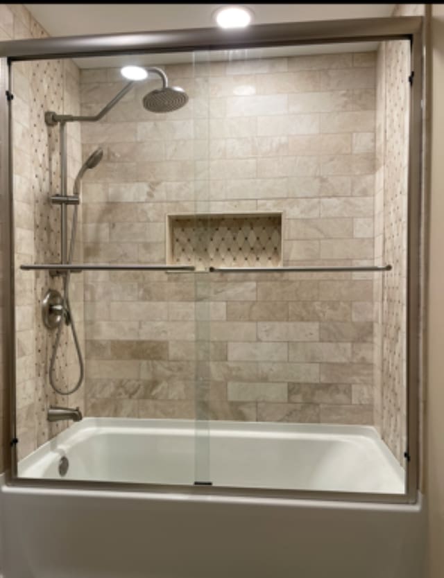 bathroom featuring bath / shower combo with glass door
