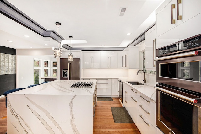 8411 Jordan Rd, Grand Blanc, MI 48439 - kitchen featuring appliances with stainless steel finishes, a kitchen island, light wood-style flooring, white cabinetry, and recessed lighting