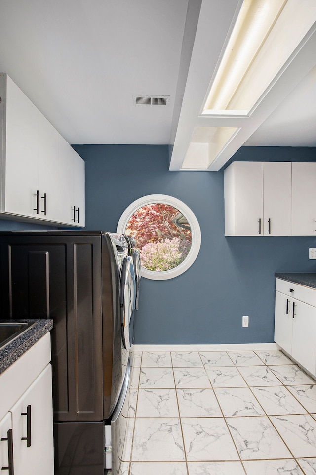 8411 Jordan Rd, Grand Blanc, MI 48439 - washroom featuring cabinet space, light marble finish floors, baseboards, and washer and dryer