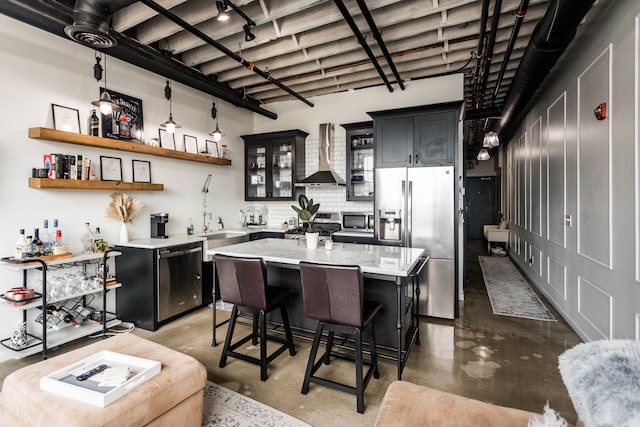 2987 Franklin St Unit 5-2D, Detroit, MI 48207 - kitchen with stainless steel appliances, wall chimney exhaust hood, concrete flooring, and dark cabinetry
