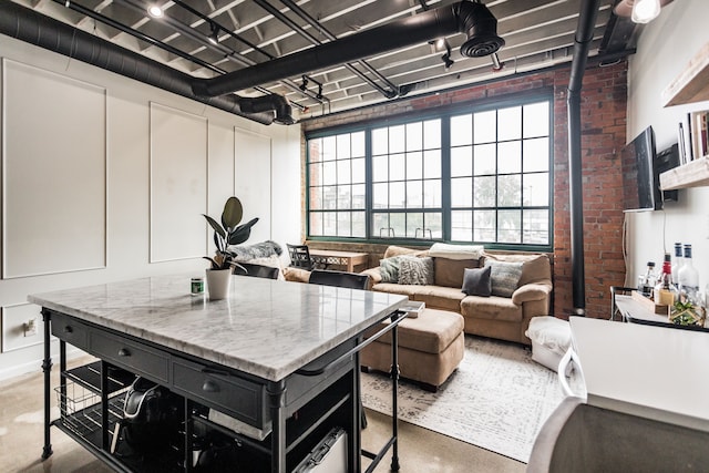 2987 Franklin St Unit 5-2D, Detroit, MI 48207 - kitchen with finished concrete floors, brick wall, and a center island