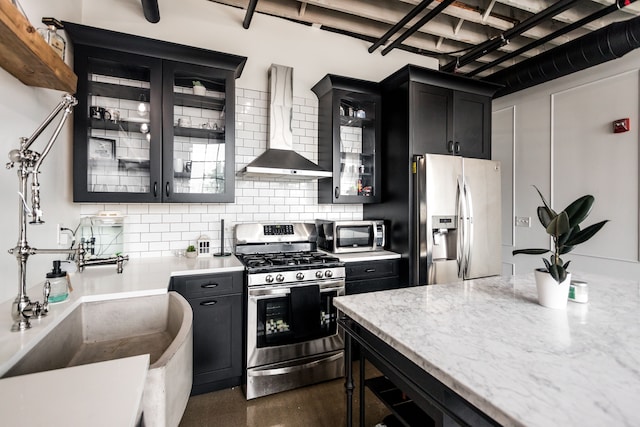 2987 Franklin St Unit 5-2D, Detroit, MI 48207 - kitchen with stainless steel appliances, wall chimney range hood, dark cabinetry, and decorative backsplash