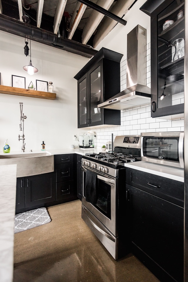 2987 Franklin St Unit 5-2D, Detroit, MI 48207 - kitchen featuring stainless steel range with gas stovetop, dark cabinets, wall chimney range hood, and backsplash