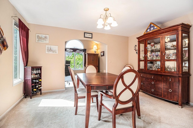 454 Breconshire Dr, Saline, MI 48176 - dining space with arched walkways, light colored carpet, a chandelier, and baseboards