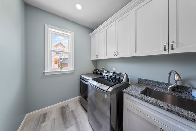laundry room with independent washer and dryer, light wood finished floors, cabinet space, baseboards, and recessed lighting