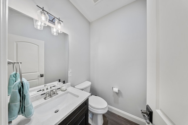 bathroom featuring baseboards, toilet, wood finished floors, vanity, and lofted ceiling