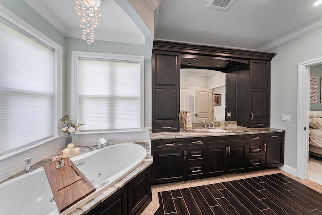 bathroom featuring a tub with jets, ornamental molding, vanity, plenty of natural light, and wood finish floors