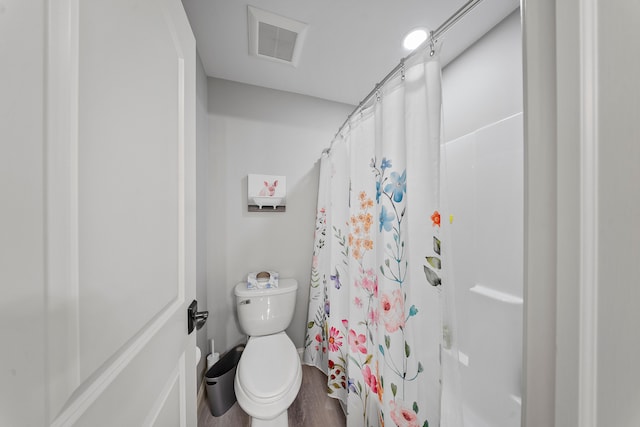 full bathroom featuring toilet, wood finished floors, and curtained shower