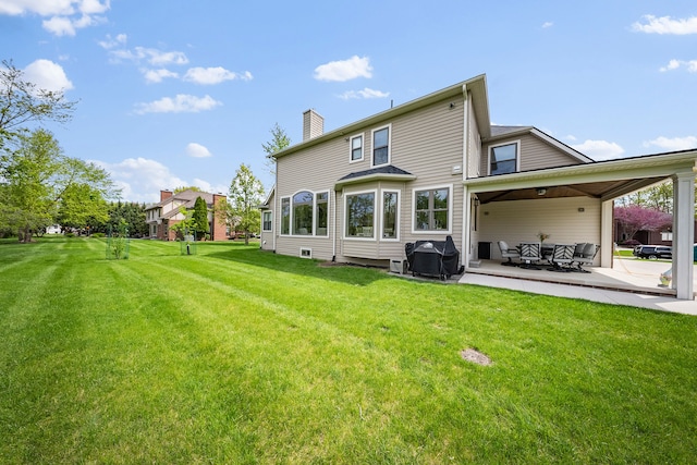 back of property featuring a patio area, a chimney, a yard, and an outdoor hangout area