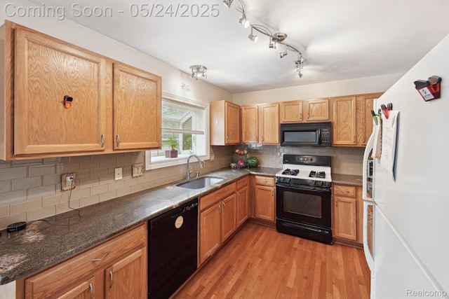 7366 Meadow Ln, Ypsilanti, MI 48197 - kitchen with black appliances, a sink, light wood-style flooring, tasteful backsplash, and dark stone countertops