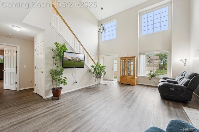7366 Meadow Ln, Ypsilanti, MI 48197 - living area with a towering ceiling, stairway, wood finished floors, plenty of natural light, and baseboards