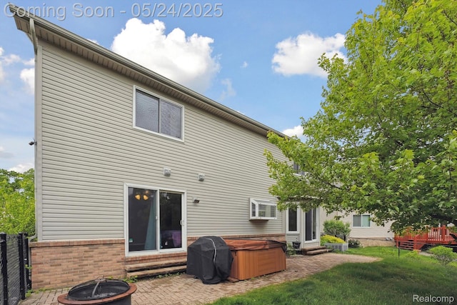 7366 Meadow Ln, Ypsilanti, MI 48197 - rear view of property featuring entry steps, a patio area, an outdoor fire pit, brick siding, and a hot tub