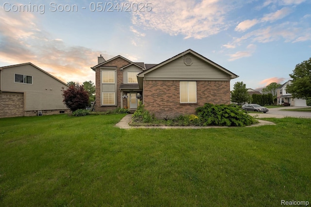 7366 Meadow Ln, Ypsilanti, MI 48197 - view of front of house with brick siding, a yard, and a chimney