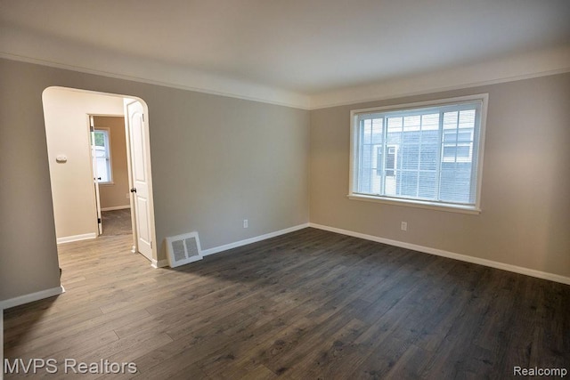 20484 Roscommon St, Harper Woods, MI 48225 - unfurnished room with baseboards, dark wood-type flooring, arched walkways, and crown molding