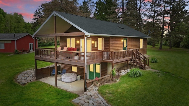 view of front of home with a patio area, faux log siding, concrete driveway, a deck, and a front lawn