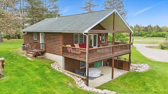 rear view of property featuring a patio area, a lawn, log veneer siding, a wooden deck, and roof with shingles