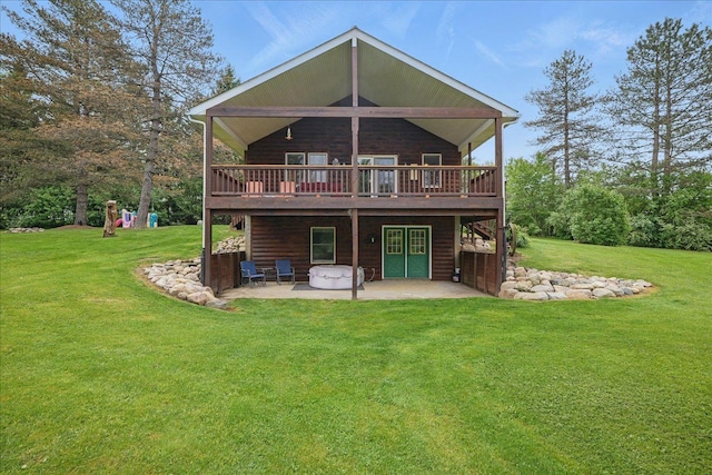 rear view of house featuring a patio area, a wooden deck, and a lawn