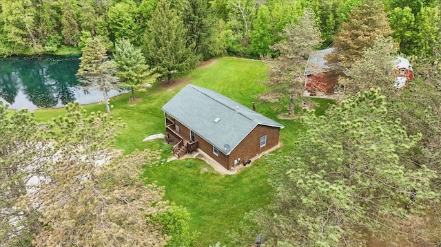 view from above of property featuring a nearby body of water and a heavily wooded area