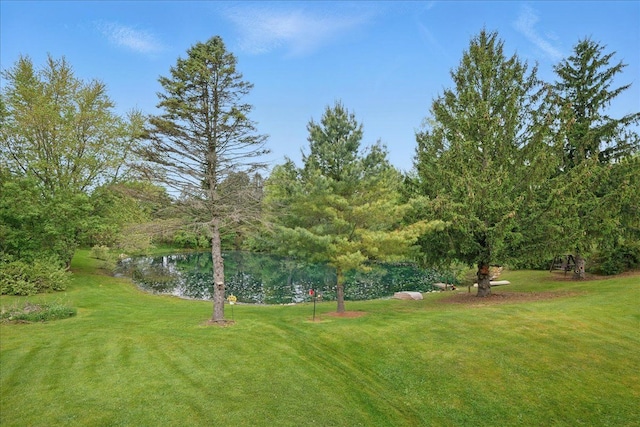 view of green lawn featuring a water view