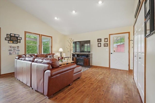 living area with healthy amount of natural light, light wood-type flooring, lofted ceiling, baseboards, and recessed lighting