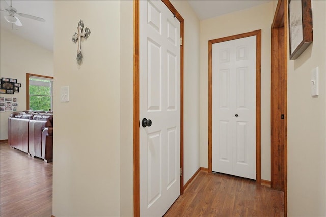 hallway featuring wood finished floors and baseboards