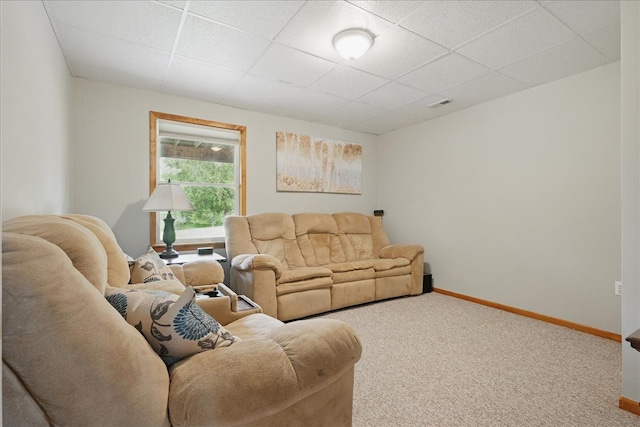 living room with a paneled ceiling, carpet floors, and baseboards