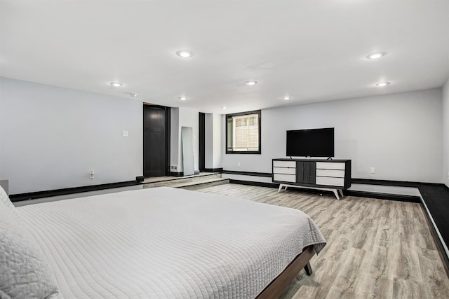 bedroom with light wood finished floors, recessed lighting, and baseboards