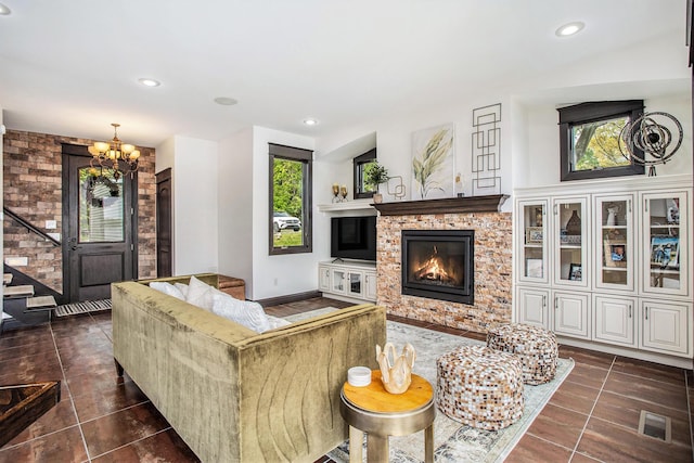 living room featuring plenty of natural light, a fireplace, a chandelier, dark tile patterned flooring, and recessed lighting