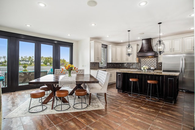 dining space with recessed lighting, a chandelier, and french doors