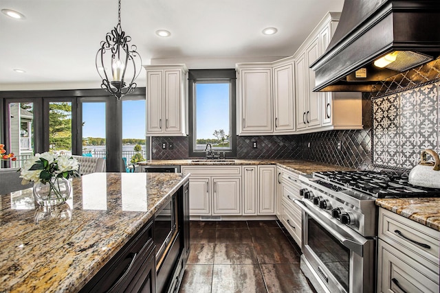 kitchen featuring high end stainless steel range, custom range hood, a sink, healthy amount of natural light, and recessed lighting