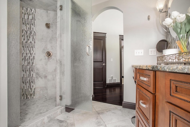 full bathroom with a stall shower, vanity, and tile patterned flooring