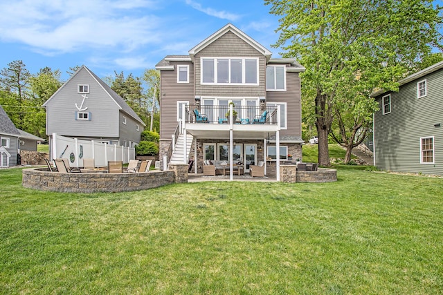 rear view of property featuring an outdoor living space, a patio, a lawn, stone siding, and a balcony