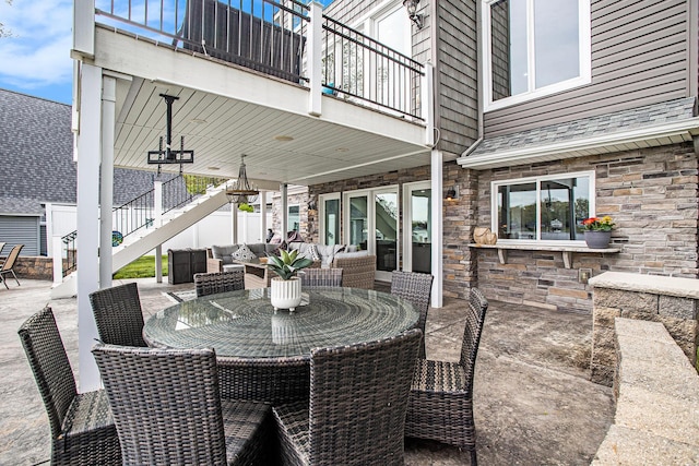 view of patio featuring an outdoor hangout area, stairway, outdoor dining space, and a balcony