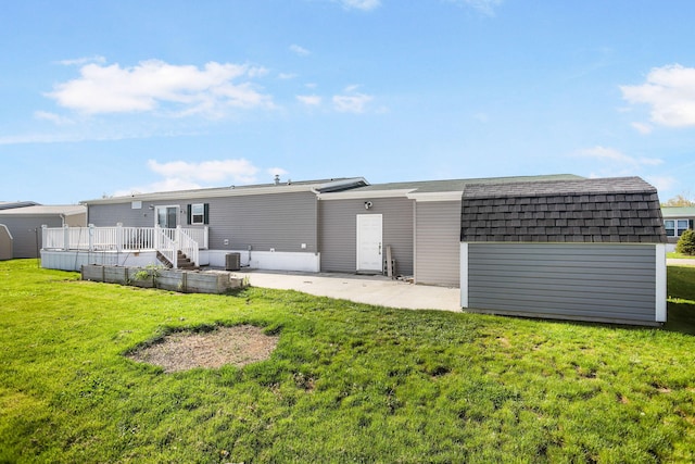 rear view of house featuring a shed, an outdoor structure, a patio area, a lawn, and a wooden deck