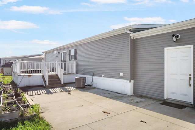 rear view of house featuring a patio, a wooden deck, and central AC