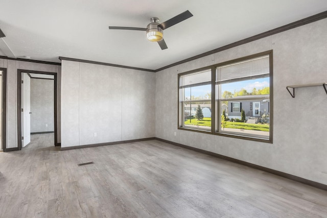 unfurnished room featuring ornamental molding, wood finished floors, ceiling fan, and baseboards