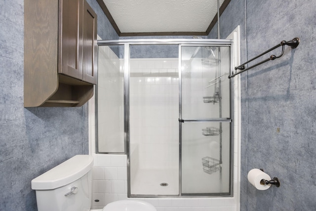 bathroom featuring a stall shower, toilet, and a textured ceiling