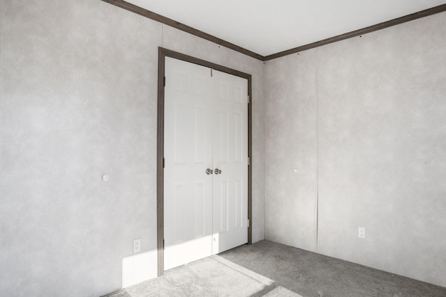 unfurnished bedroom featuring carpet and crown molding